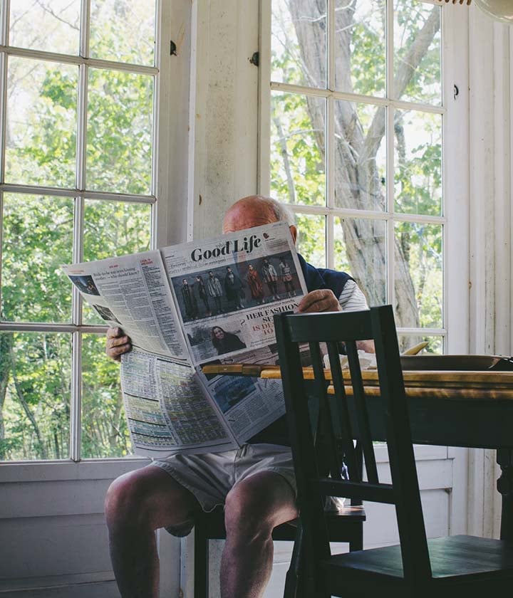 retired man reading newspaper